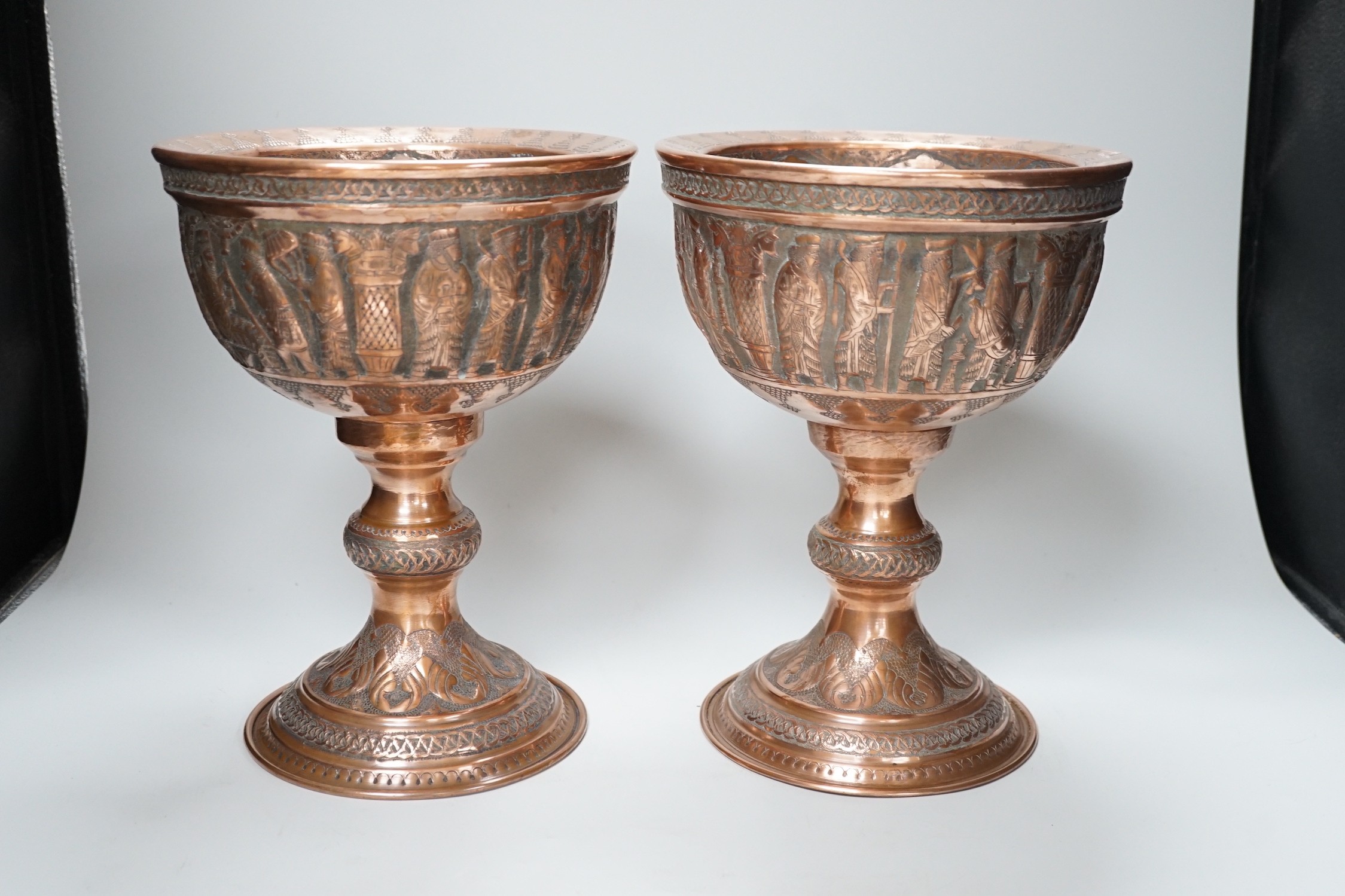 A pair of Persian copper figural decorated chalices, 27cms high
